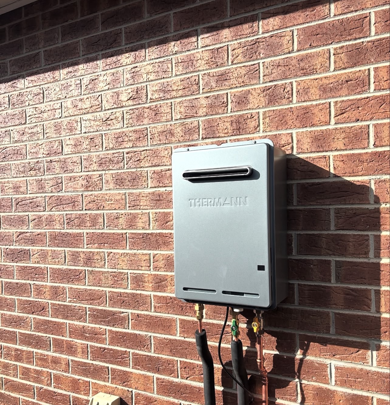 Thermann continuous flow hot water system installed on brick wall Box Hill Melbourne